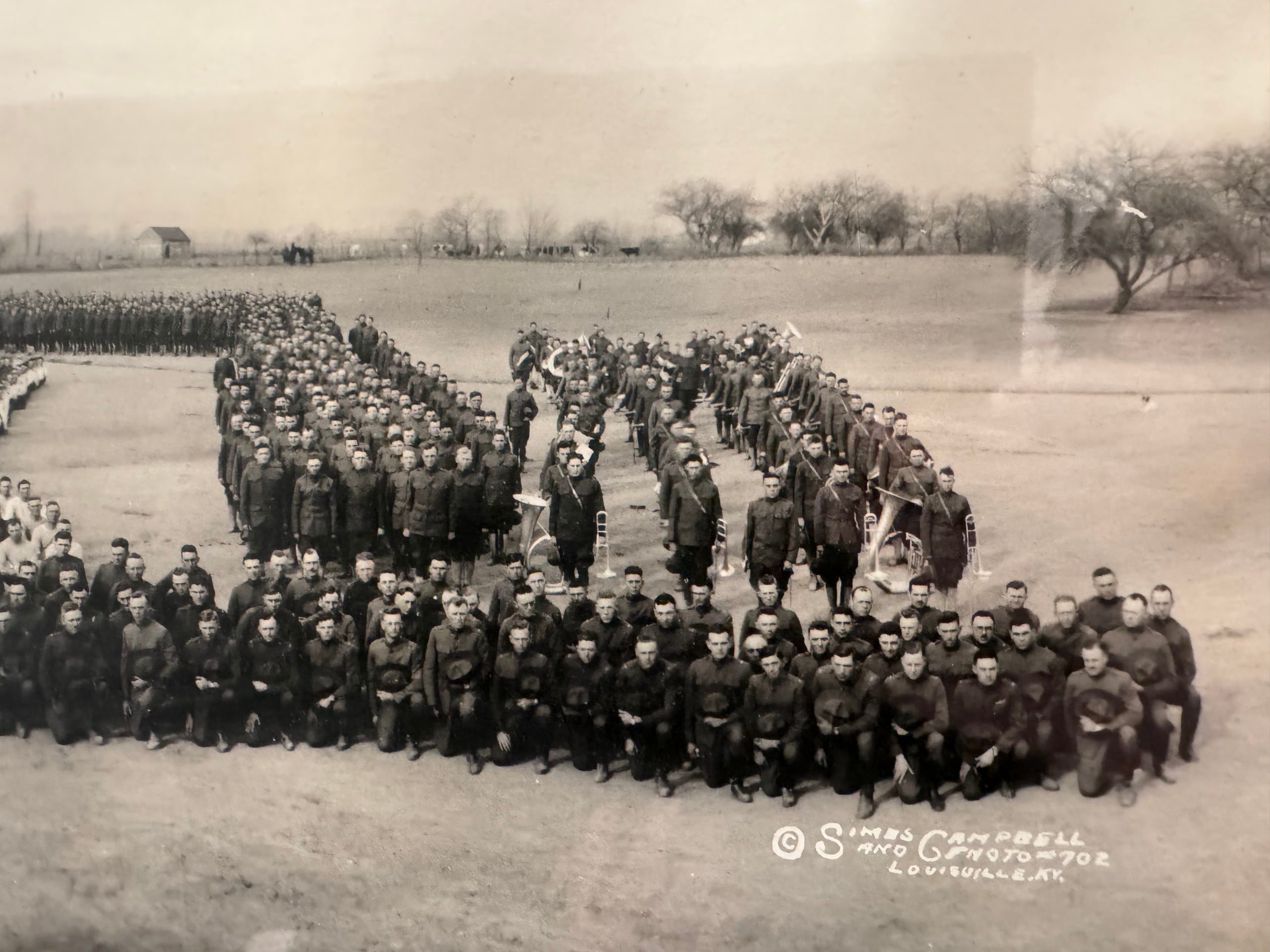 Aerial photograph of Camp Knox artillery trainees forming large letters and unit symbols on the West Point training grounds.